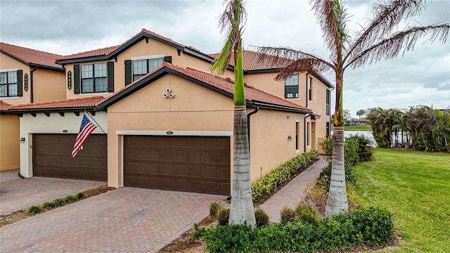 mediterranean / spanish-style house featuring a garage and a front lawn