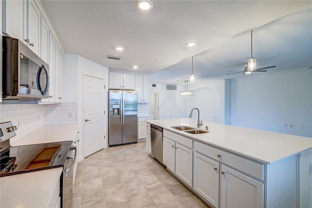 kitchen featuring white cabinets, sink, stainless steel appliances, and an island with sink