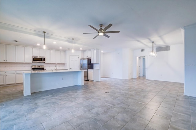 kitchen with pendant lighting, white cabinets, a center island with sink, ceiling fan, and stainless steel appliances