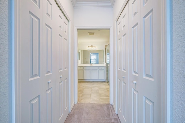 corridor featuring light carpet and ornamental molding