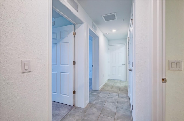 hall featuring light tile patterned floors