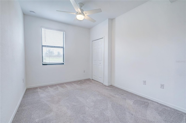 carpeted spare room with ceiling fan