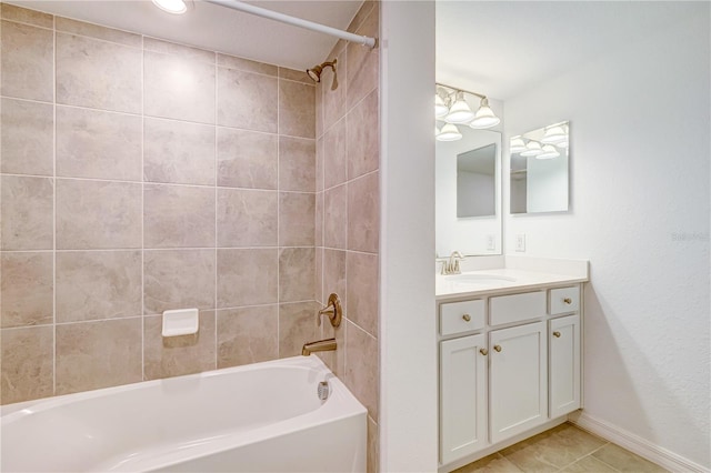 bathroom with tile patterned flooring, tiled shower / bath combo, and vanity