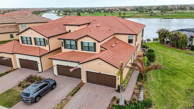 view of front of property with a water view, a garage, and a front lawn