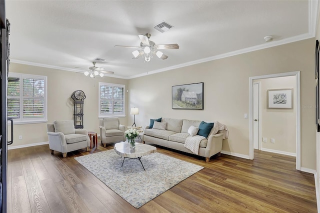 living room with ornamental molding, dark wood-type flooring, ceiling fan, and plenty of natural light