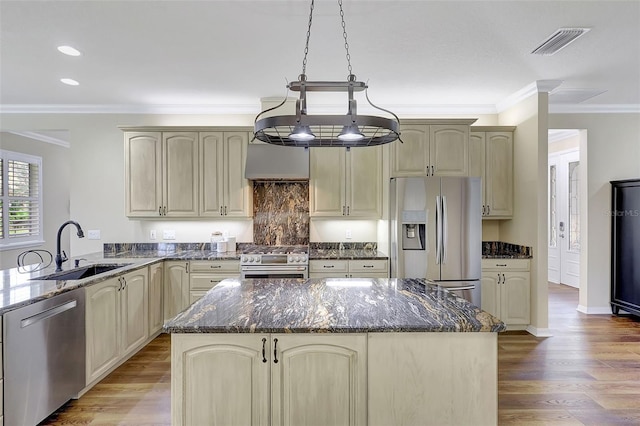 kitchen featuring appliances with stainless steel finishes, sink, light wood-type flooring, and a kitchen island