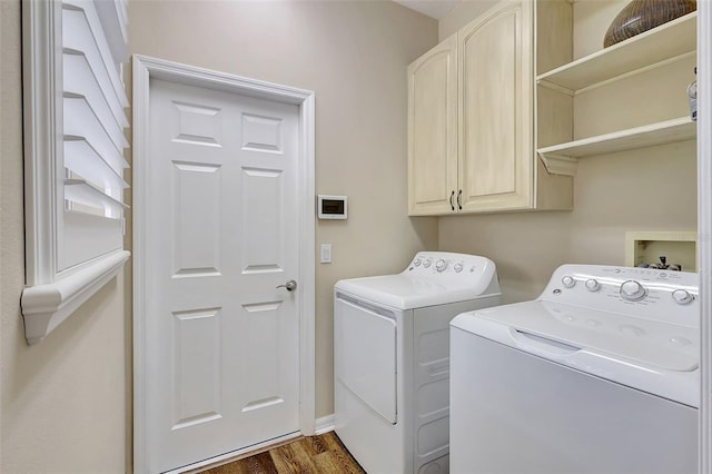 washroom featuring cabinets, washer and dryer, and dark hardwood / wood-style floors