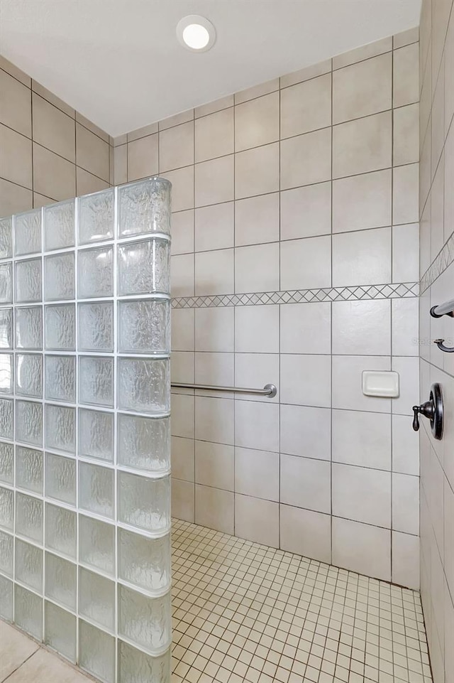 bathroom featuring tile patterned flooring and tiled shower