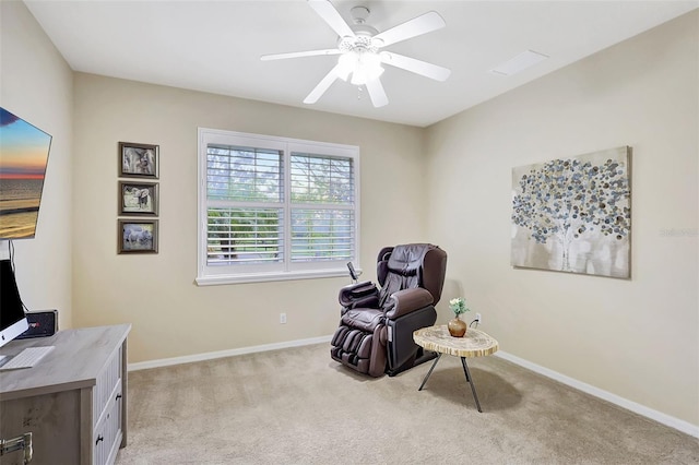 living area featuring light carpet and ceiling fan