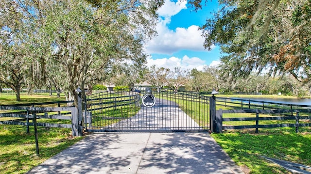 view of gate featuring a water view and a yard