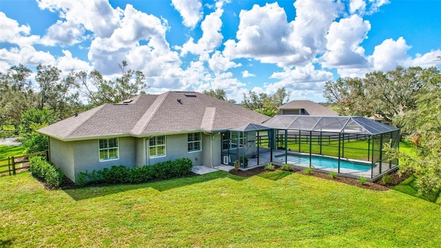 back of house with a lawn and glass enclosure