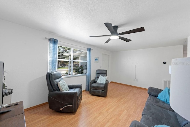 living room featuring hardwood / wood-style floors, a textured ceiling, and ceiling fan