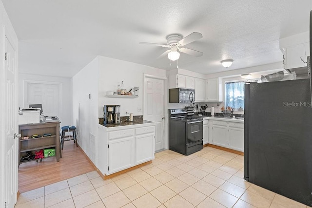 kitchen with light wood-type flooring, a textured ceiling, ceiling fan, black appliances, and white cabinetry