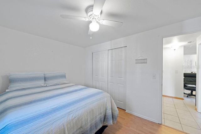 bedroom featuring ceiling fan, a closet, and light hardwood / wood-style flooring