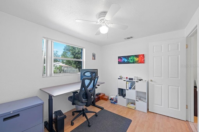 office with ceiling fan, light hardwood / wood-style floors, and a textured ceiling