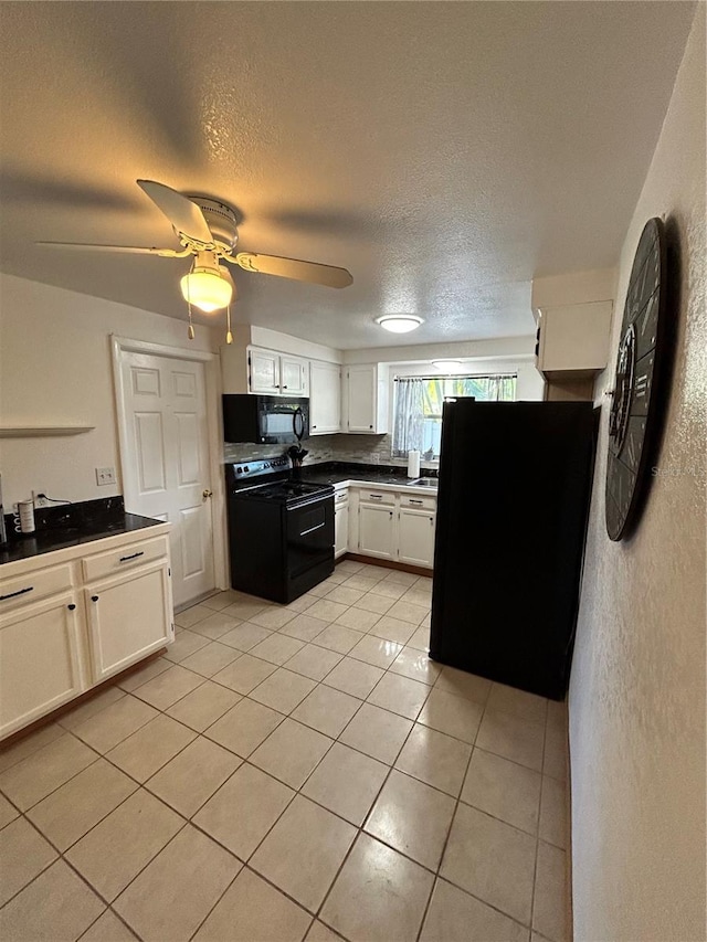 kitchen featuring black appliances, light tile patterned flooring, white cabinetry, and a textured ceiling