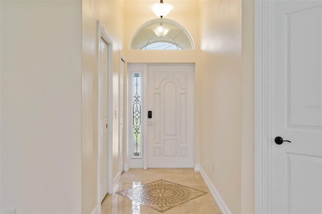 tiled entrance foyer featuring a towering ceiling