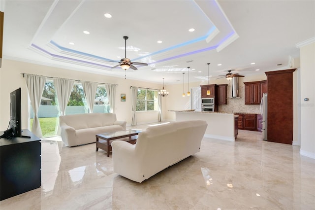 living room with a raised ceiling, a wealth of natural light, and crown molding