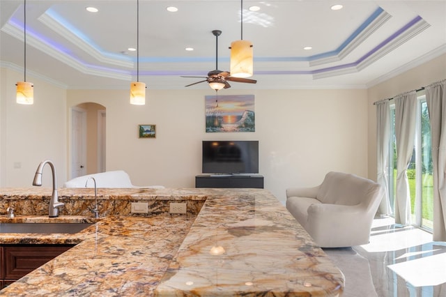 living room with ceiling fan, crown molding, sink, and a tray ceiling