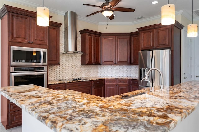 kitchen with tasteful backsplash, pendant lighting, wall chimney range hood, and appliances with stainless steel finishes