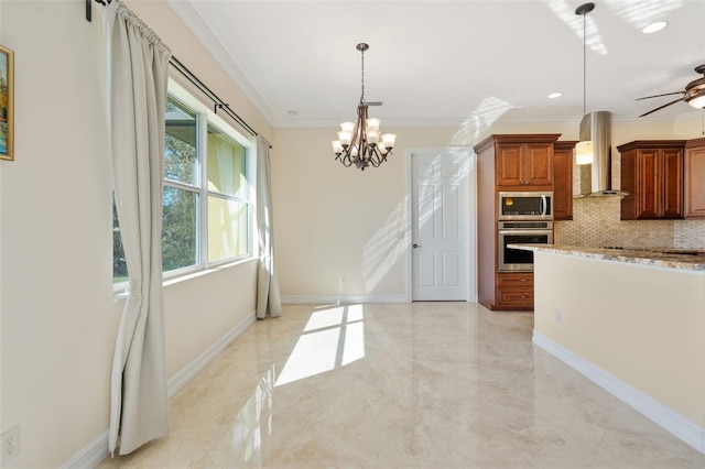 kitchen with hanging light fixtures, stainless steel appliances, wall chimney range hood, backsplash, and crown molding