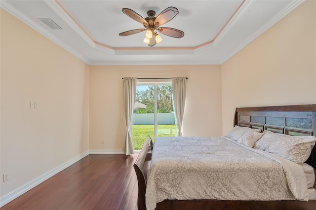 bedroom with access to exterior, ceiling fan, dark hardwood / wood-style flooring, a tray ceiling, and ornamental molding