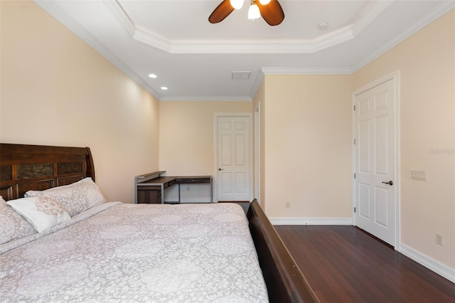 bedroom featuring dark hardwood / wood-style floors, ceiling fan, crown molding, and a tray ceiling