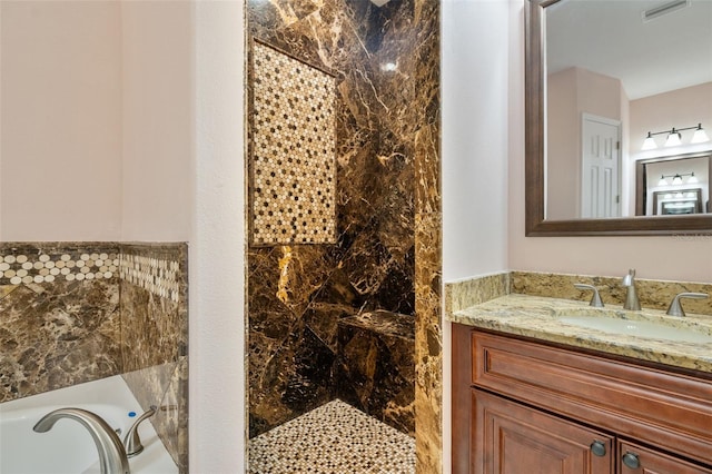 bathroom featuring tiled shower and vanity