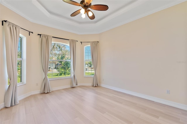 spare room featuring ceiling fan, light hardwood / wood-style floors, a raised ceiling, and ornamental molding