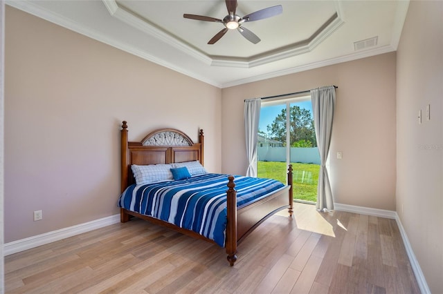 bedroom featuring ceiling fan, a raised ceiling, ornamental molding, and access to outside