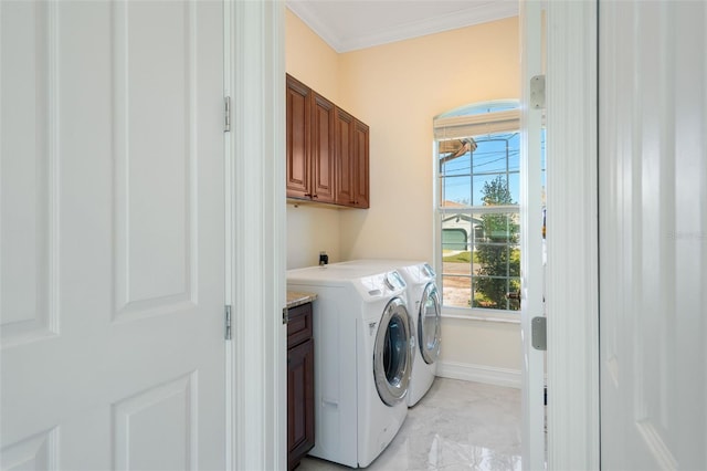 laundry room featuring washer and dryer, cabinets, and crown molding