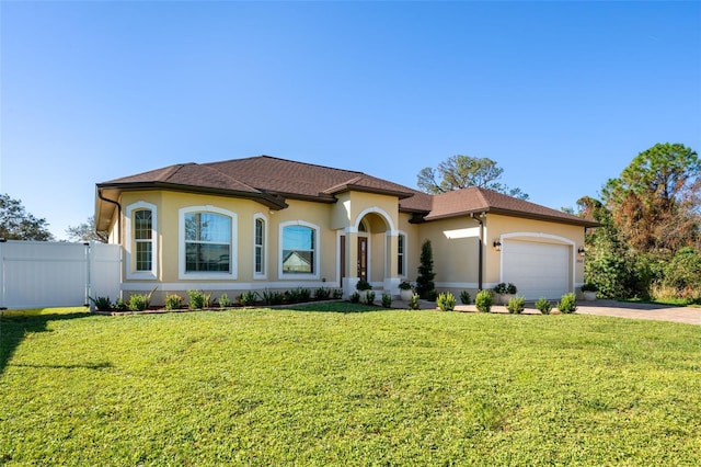 mediterranean / spanish house featuring a front yard and a garage