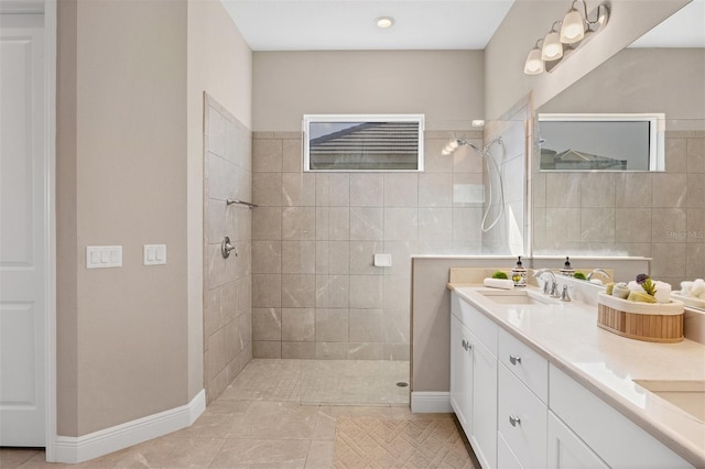 bathroom with tiled shower, tile patterned floors, and vanity