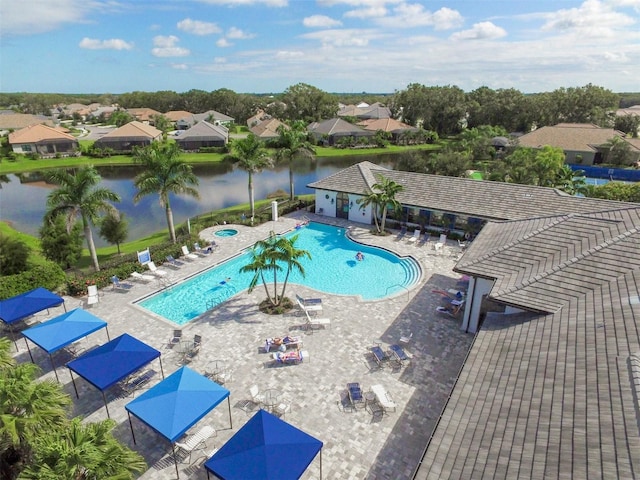 view of swimming pool featuring a water view and a patio area