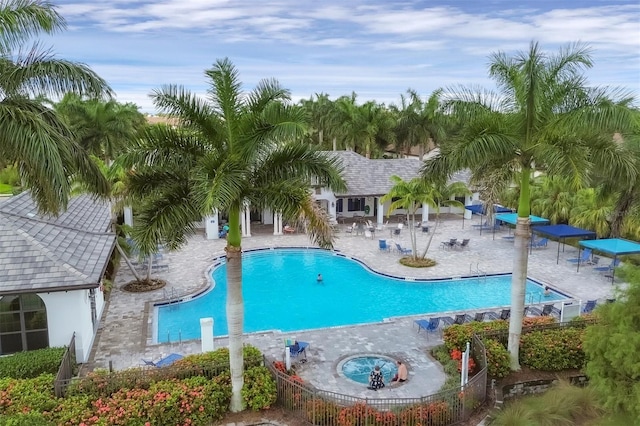 view of swimming pool featuring a hot tub and a patio