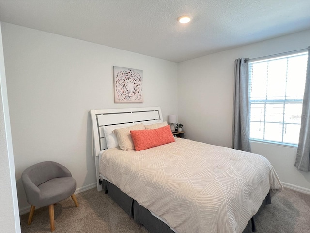 bedroom featuring carpet floors, multiple windows, and baseboards