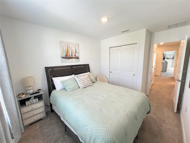 bedroom featuring a closet, a textured ceiling, and carpet flooring