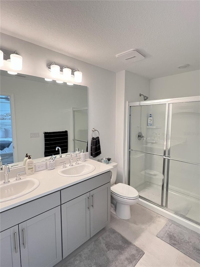 bathroom featuring vanity, a textured ceiling, walk in shower, and toilet