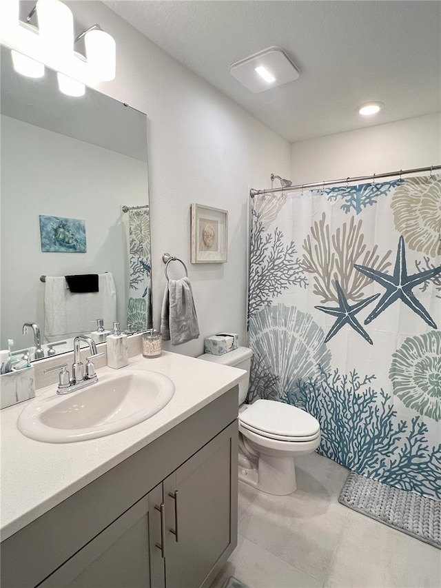 bathroom with vanity, toilet, curtained shower, and tile patterned flooring