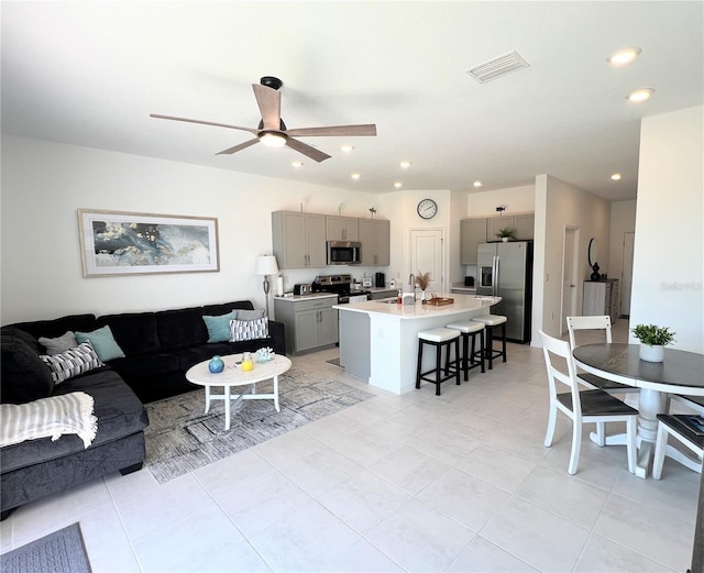 living area with recessed lighting, visible vents, and ceiling fan