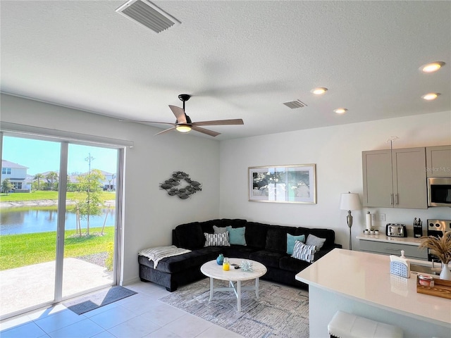 living area with ceiling fan, visible vents, a textured ceiling, and recessed lighting