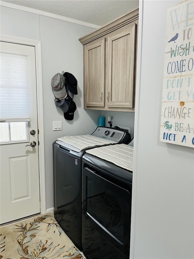 laundry room with cabinets, washer and dryer, and a textured ceiling