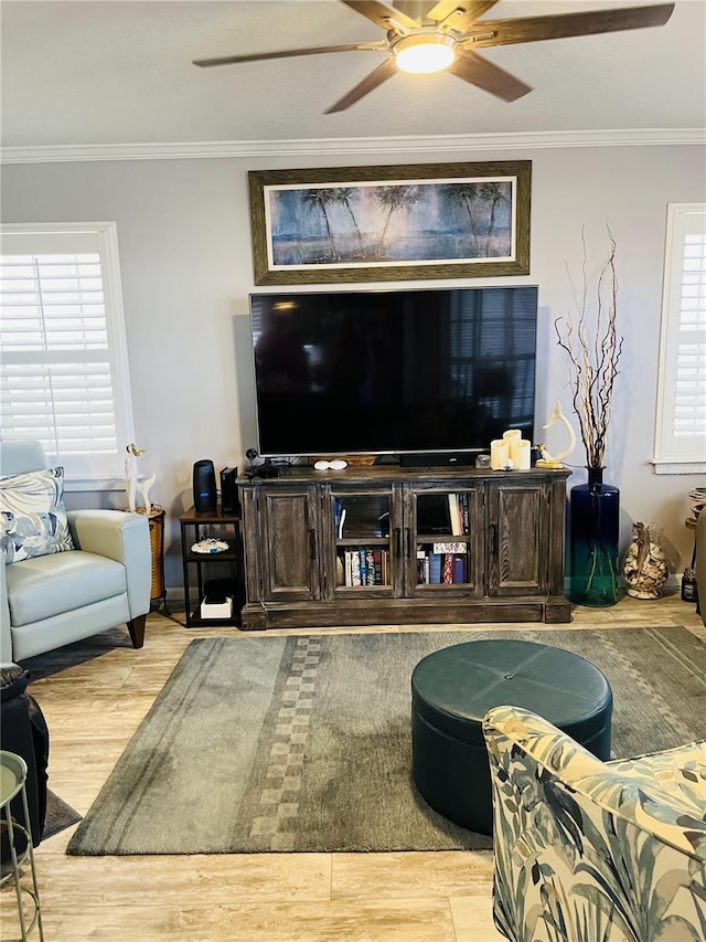 living room featuring hardwood / wood-style floors, ceiling fan, and crown molding