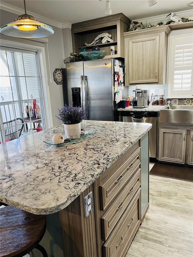 kitchen featuring a kitchen breakfast bar, crown molding, pendant lighting, light wood-type flooring, and stainless steel fridge