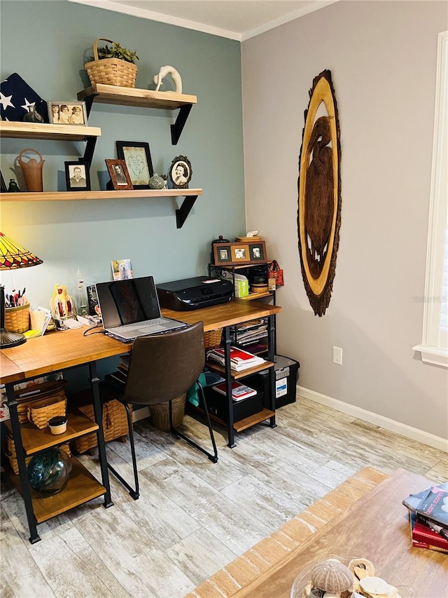 office space featuring light wood-type flooring and crown molding