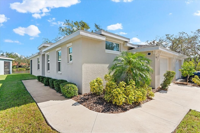 view of property exterior with a garage and a lawn