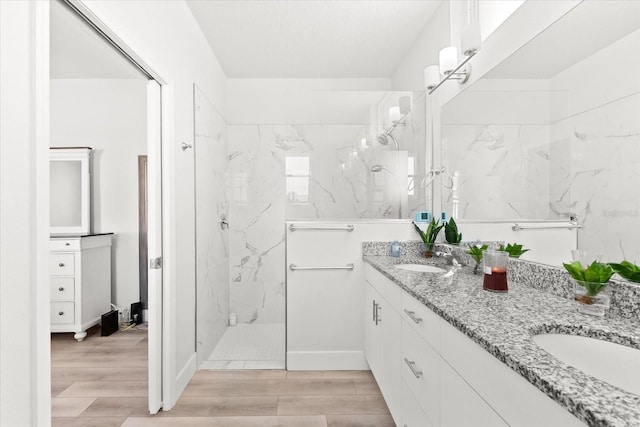 bathroom featuring vanity, hardwood / wood-style flooring, and a tile shower