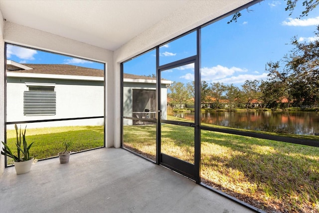 unfurnished sunroom featuring a water view