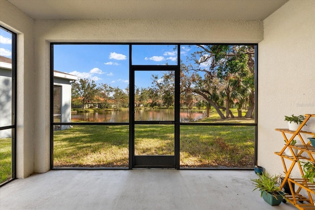 unfurnished sunroom featuring a water view