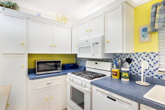 kitchen with white cabinets, tasteful backsplash, and white appliances